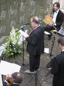 905687 Afbeelding van een optreden van dichter-schrijver Gerrit Komrij en een klein muziekgezelschap op de werf langs ...